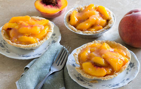 Three fresh peach tarts.