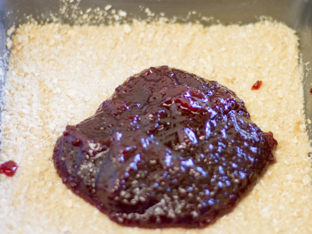 cranberry mixture in pan on oat crumbs.