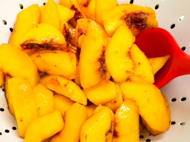 Sliced peaches in colander.