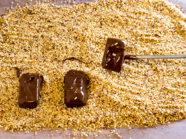 Toffee pieces dipped in chocolate on bed of finely chopped almonds