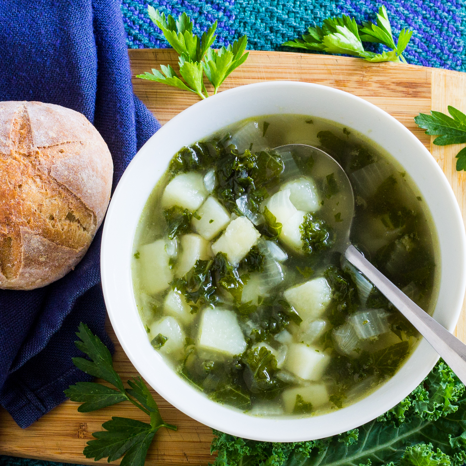 Bowl of kale potato soup French roll
