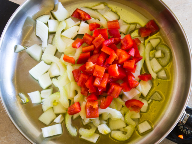 olive oil, yellow onion, bell pepper, and celery in frying pan