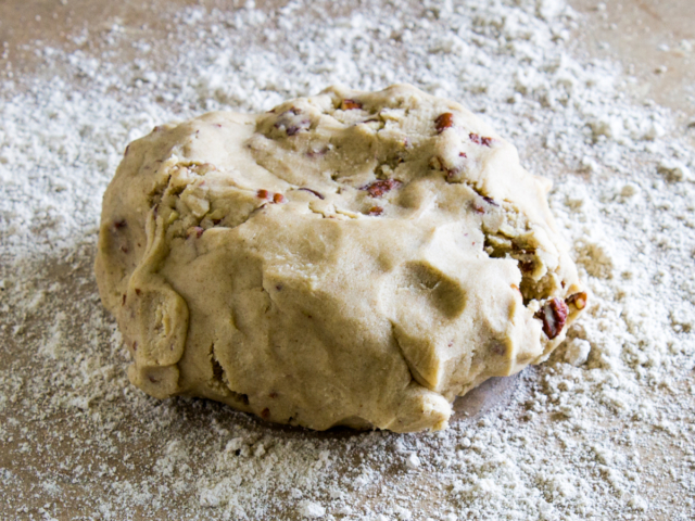 Ball of cookie dough on counter dusted with oat flour.
