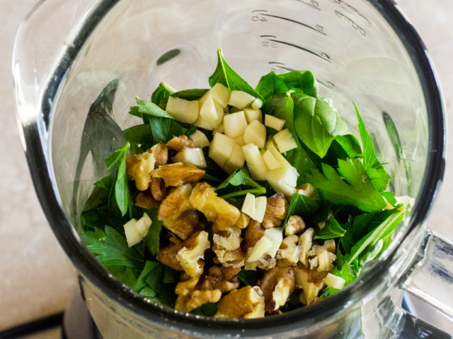 Basil leaves, garlic, chopped parsley, walnut pieces, and salt in blender