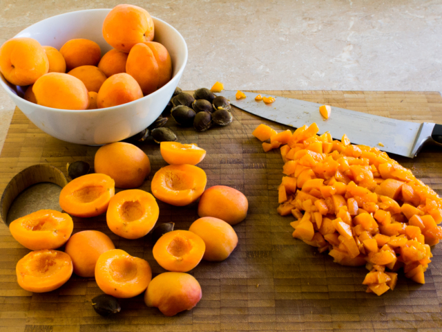Bowl of apricots with pitted apricots and chopped apricots.