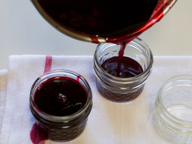 Pouring jelly into hot sterilized half-cup jars.