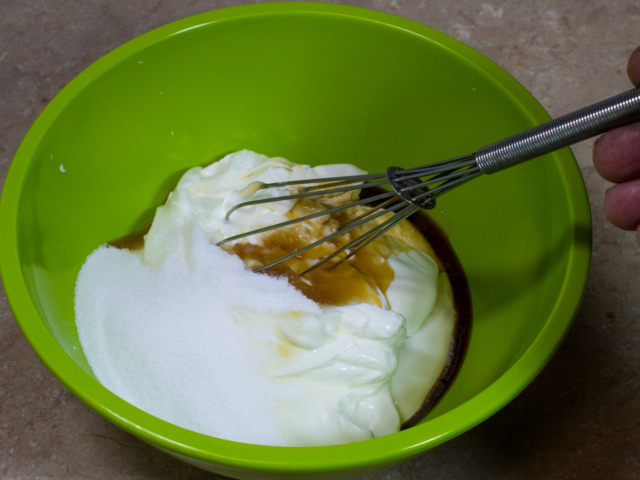 Sour cream, sugar, and vanilla flavoring in a large green bowl. Stir together.