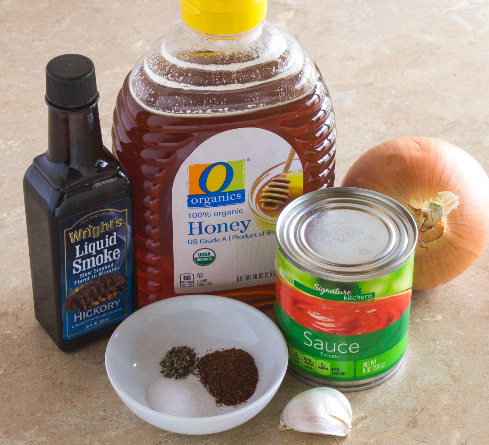Ingredients for honey barbecue sauce honey yellow onion liquid smoke can of tomato sauce garlic and spices