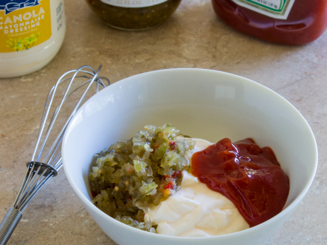 Pressed relish, mayonnaise, and ketchup in a white bowl.
